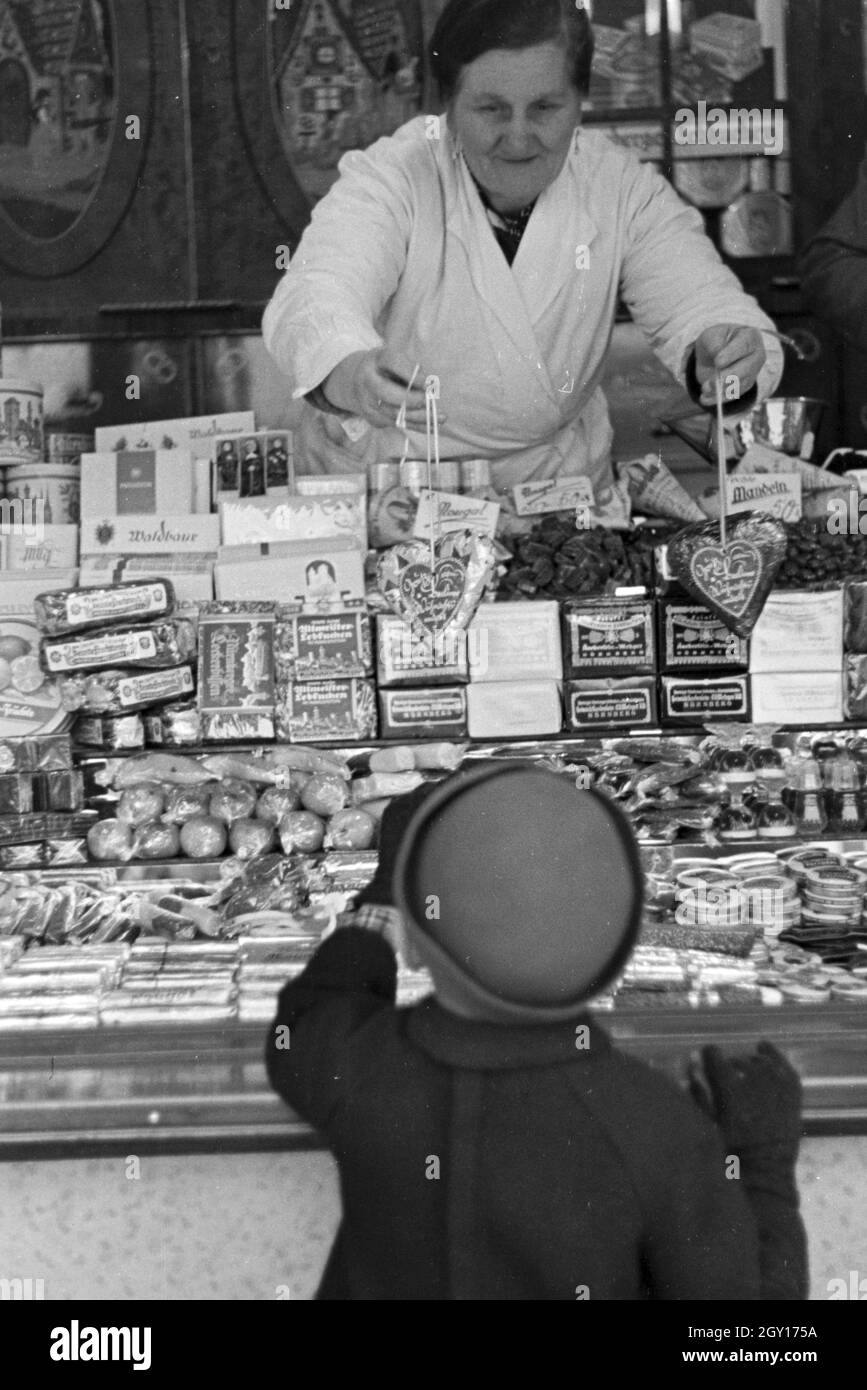 Ein kleiner Junge auf dem Weihnachtsmarkt, Deutsches Reich 1930er Jahre. Un ragazzino sul mercato di Natale, Germania 1930s. Foto Stock