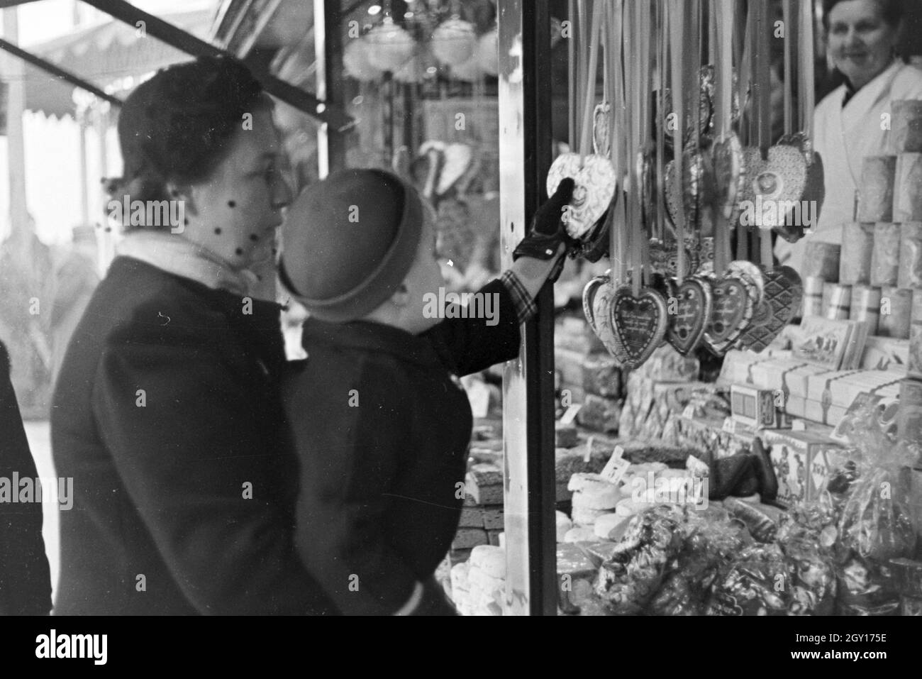 Eine Mutter mit ihrem kleinen Sohn auf dem Weihnachtsmarkt, Deutsches Reich 1930er Jahre. Una donna con il suo piccolo figlio sul mercato di Natale, Germania 1930s. Foto Stock