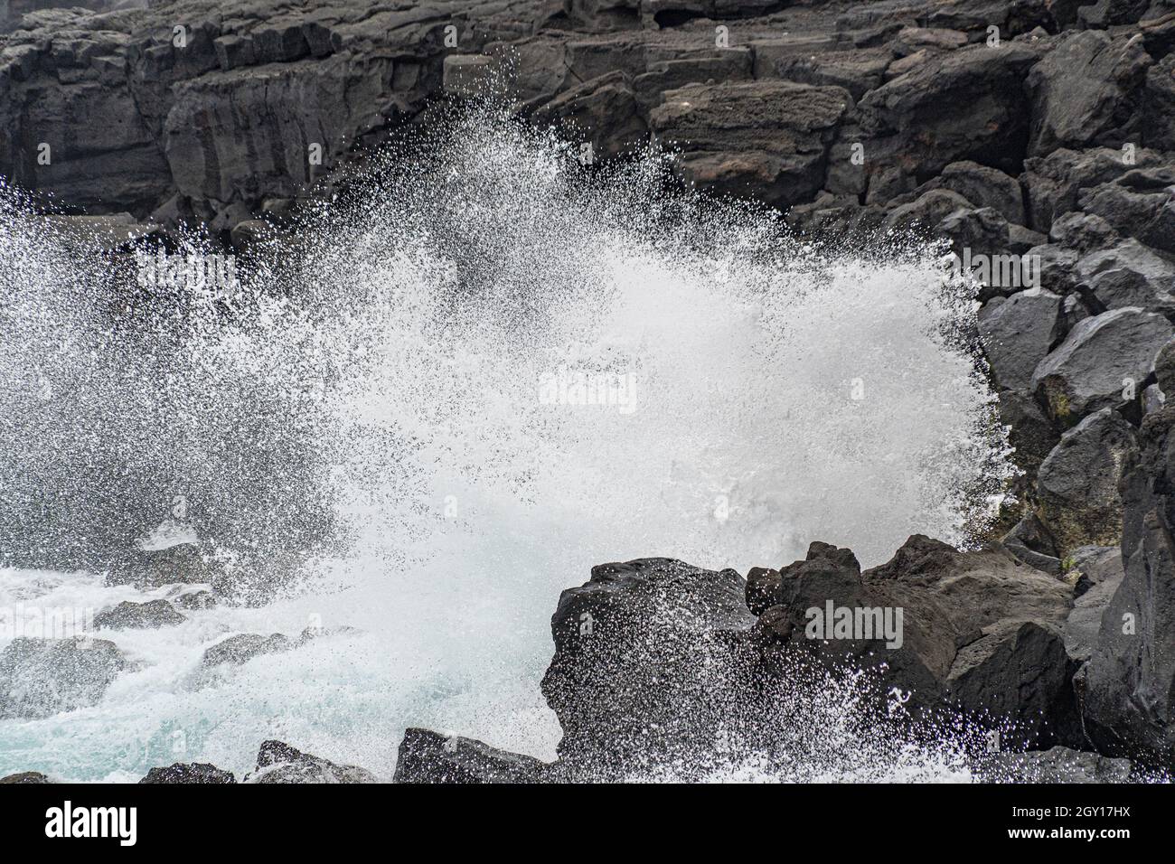 infrangendo le onde di mare in tempesta sul paesaggio di roccia lavica Foto Stock