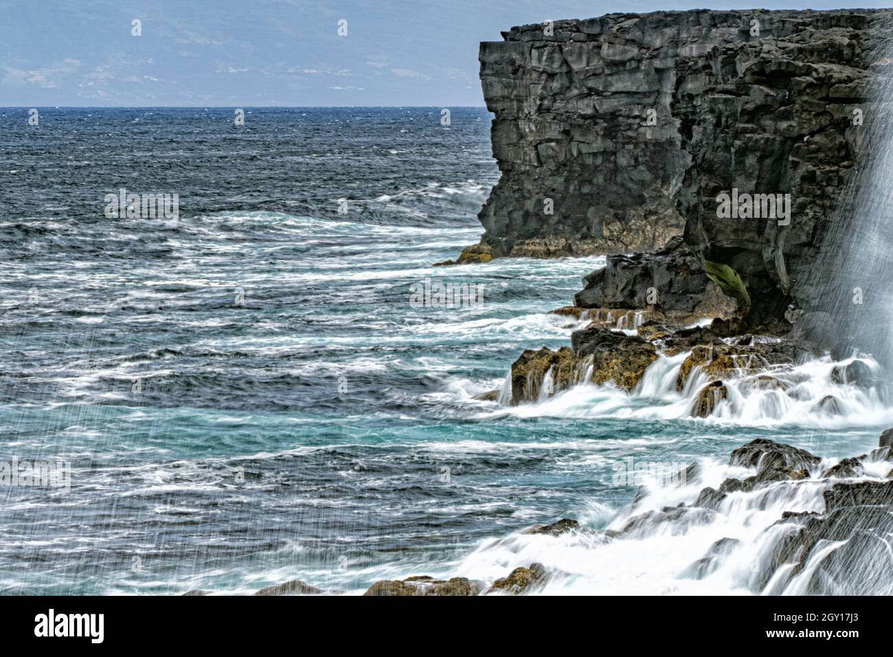 infrangendo le onde di mare in tempesta sul paesaggio di roccia lavica Foto Stock