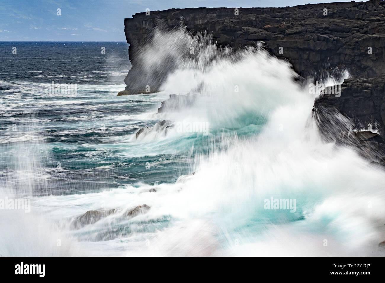 infrangendo le onde di mare in tempesta sul paesaggio di roccia lavica Foto Stock