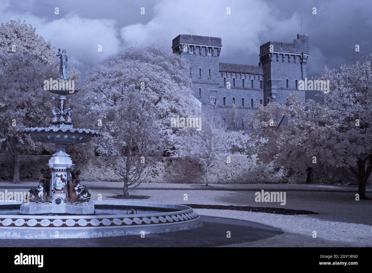 Una vista autunnale attraverso il Vivary Park a Taunton, Somerset, Inghilterra, Regno Unito, che mostra la Queen Victoria Memorial Fountain e l'ex caserma di Jellalabad. Foto Stock