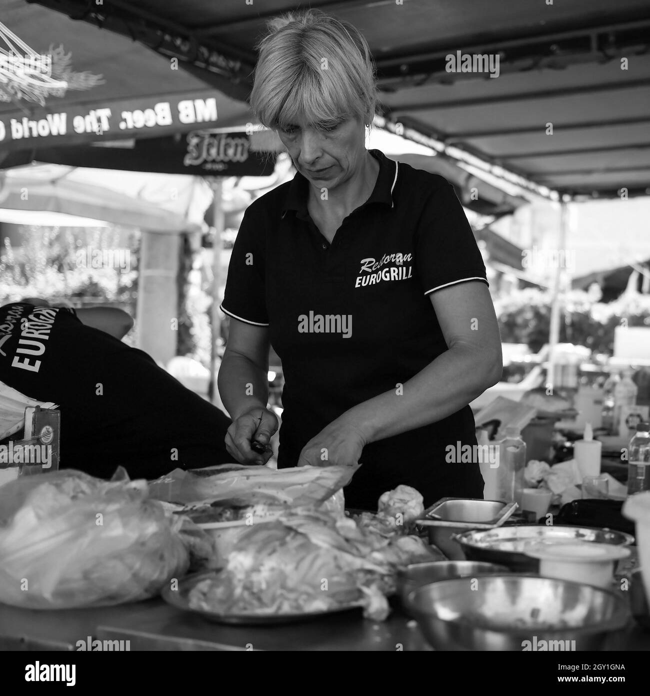 Sokobanja, Serbia, 19 agosto 2021: Donna che lavora in una cucina fast food (B/N) Foto Stock