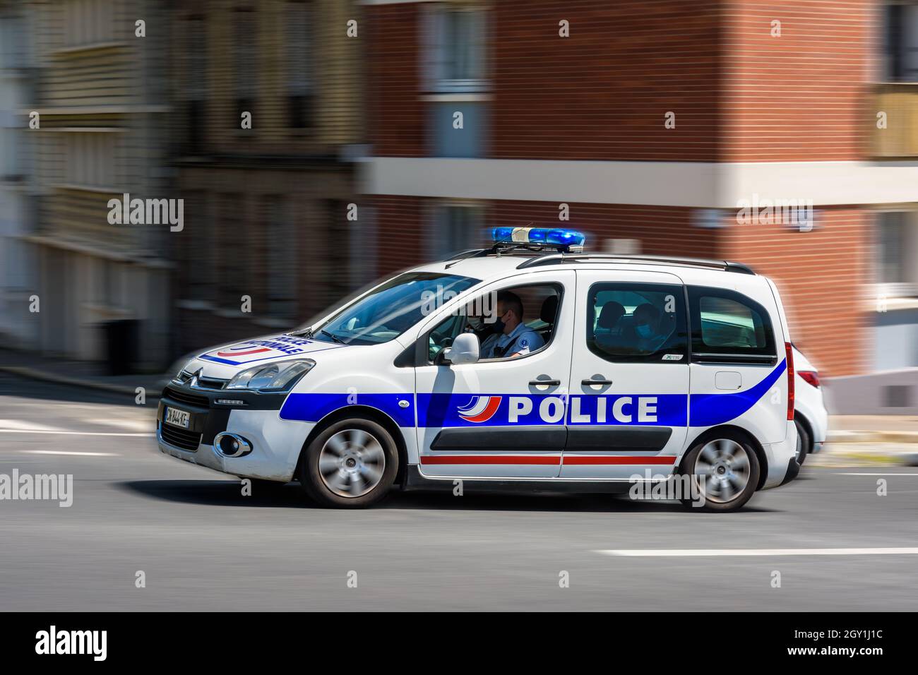Una macchina di polizia stampata a schermo dalla francese 'Police Nationale' sta accelerando nella strada con le luci di emergenza sul tetto accese. Foto Stock