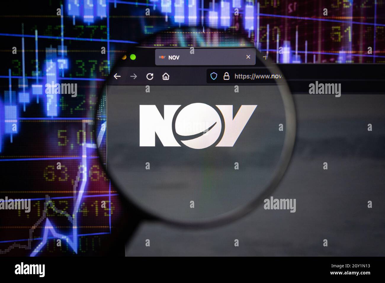 NOV azienda logo su un sito web con blurry sviluppi del mercato azionario in background, visto su uno schermo del computer attraverso una lente d'ingrandimento Foto Stock