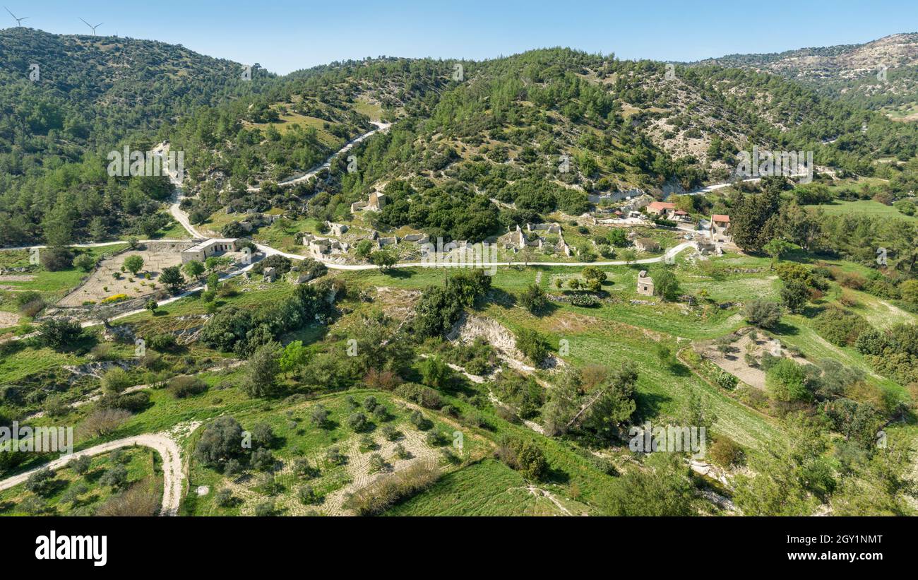 Spopolamento rurale a Cipro. Villaggio semi-abbandonato di Kato Archimandrita su un pendio collinare con antiche rovine e ristrutturato Foto Stock