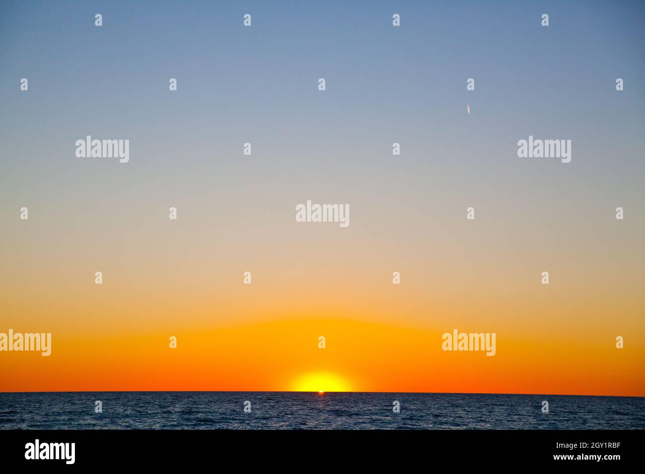 Paesaggio d'acqua e cielo oscuro come tramonta il sole Foto Stock