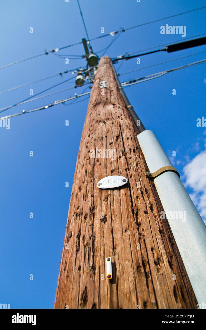 L'asta telefonica marrone in legno raggiunge un cielo blu chiaro Foto Stock