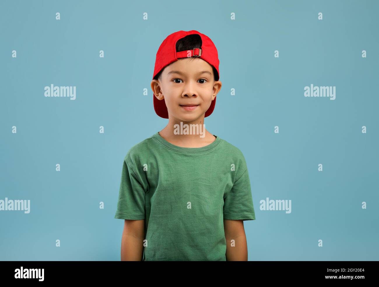 Ritratto di ragazzo asiatico carino in cappello rosso e maglietta verde Foto Stock