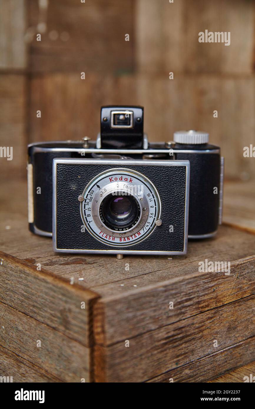 La telecamera per film d'antiquariato punta allo spettatore con il flash mentre si siede sopra una scatola di legno Foto Stock