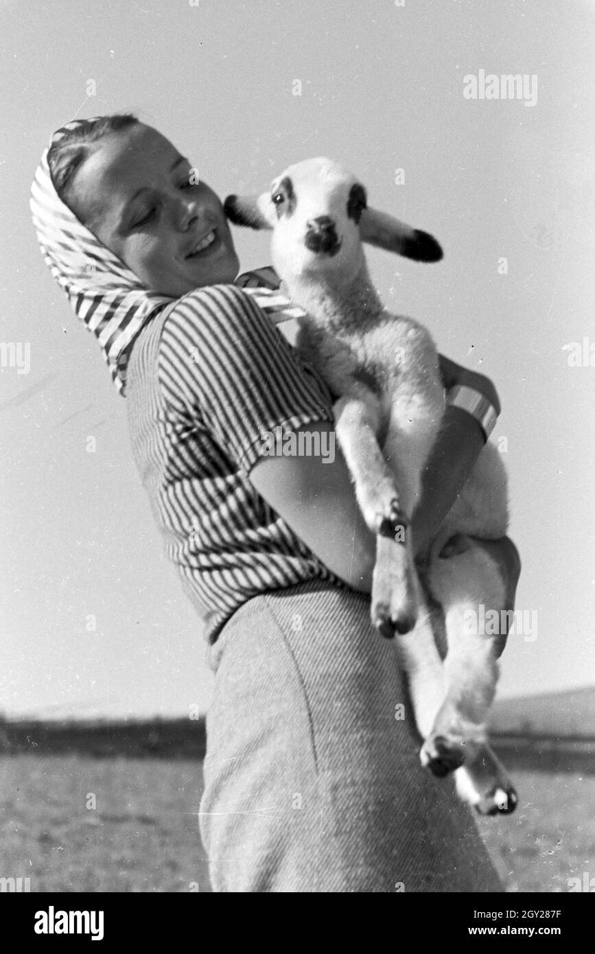 Eine junge Frau Mit einem gescheckten Zicklein, San Märgen im Südschwarzwald, Deutschland 1930er Jahre. Una giovane donna tenendo un macchiato il capretto, San Märgen nella Foresta Nera meridionale, Germania 1930s. Foto Stock