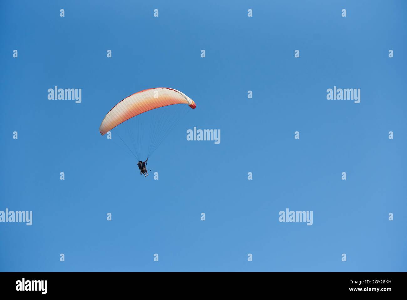 Parapendio con due persone contro il cielo blu Foto Stock