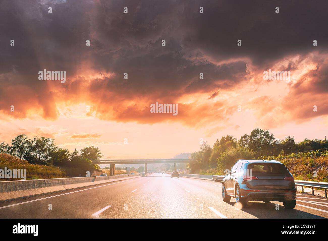 movimento dei veicoli in autostrada, autostrada durante il tramonto Foto Stock