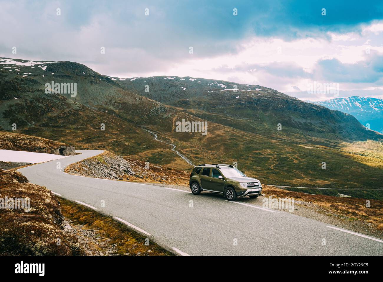 Aurlandsfjellet, Norvegia. Auto SUV parcheggiato vicino Aurlandsfjellet strada panoramica nel paesaggio estivo norvegese. Natural Norwegian Landmark e popolare Foto Stock