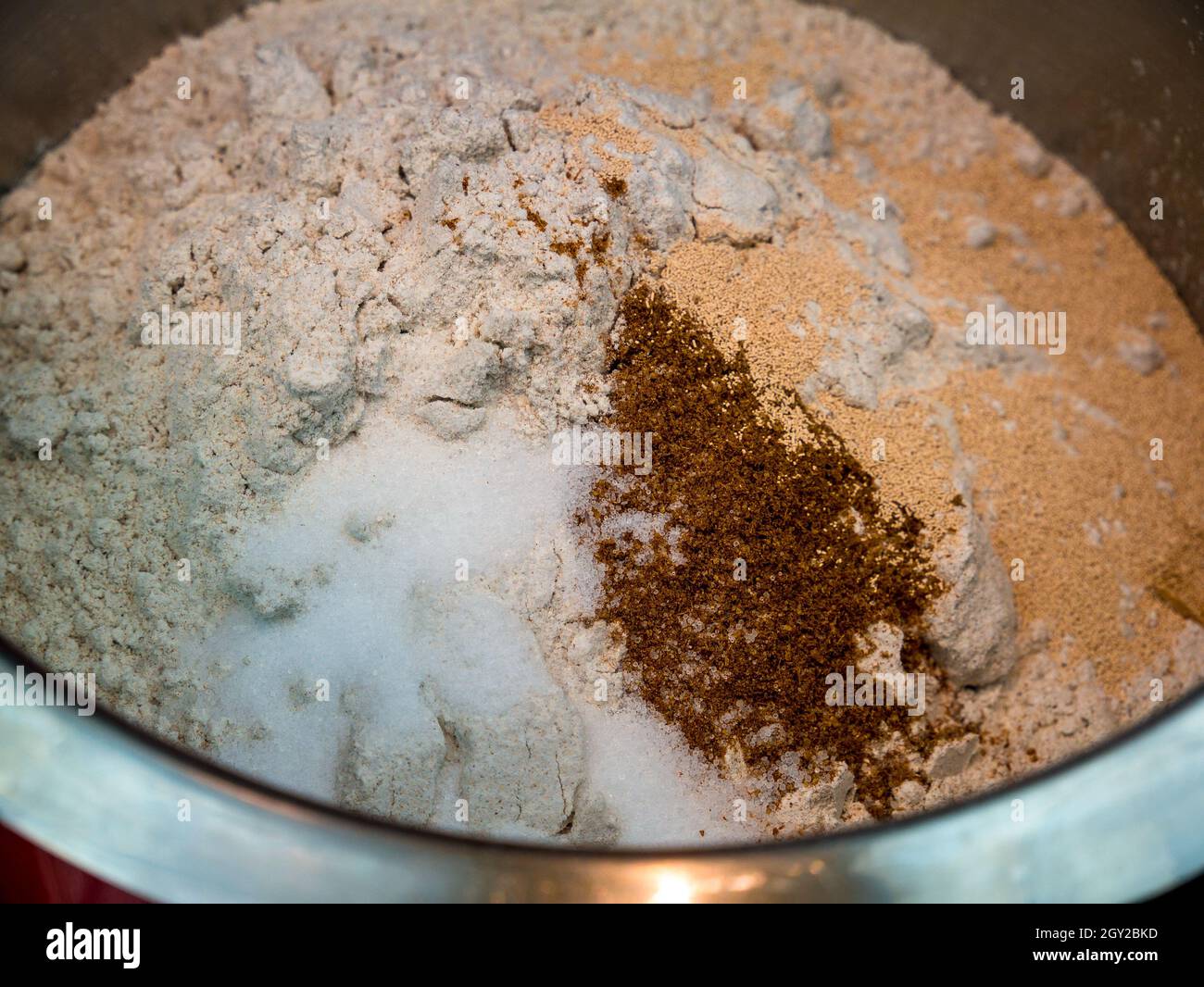 Farina di segale, sale, cumino macinato e lievito secco in un recipiente in acciaio inox - base per l'impasto del pane - fuoco selettivo Foto Stock