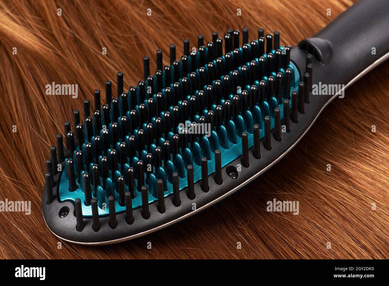 Spazzola elettrica per lisciare i capelli rossi Foto stock - Alamy