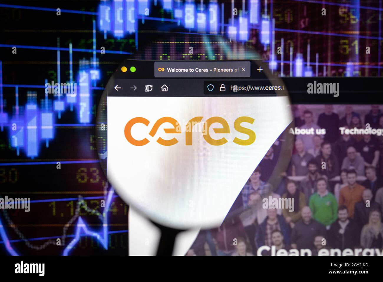 Ceres Company logo su un sito web con blurry mercato azionario sviluppi in background, visto su uno schermo di computer attraverso una lente d'ingrandimento Foto Stock