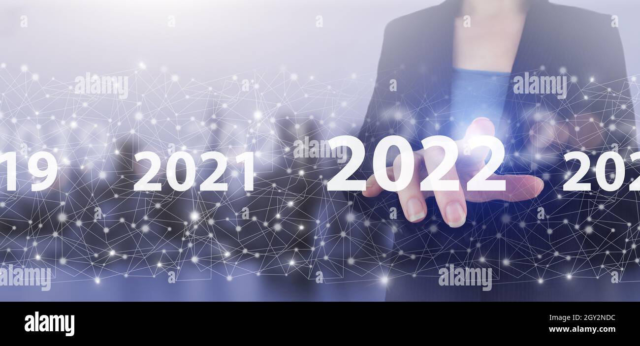 Anno di carico dal 2021 al 2022. Inizia concetto. Mano touch schermo digitale ologramma 2022 segno sulla città luce sfondo sfocato. Nuovo anno 2022,obiettivo,piano,attività Foto Stock