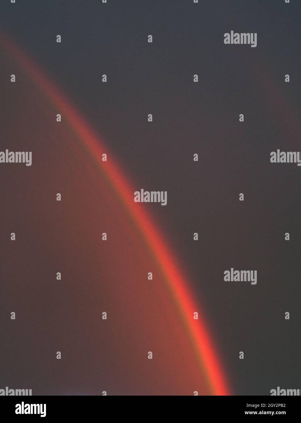 sfondo naturale astratto. Un arcobaleno su un cielo oscuro e tempestoso al tramonto. Spazio di copia. Foto Stock