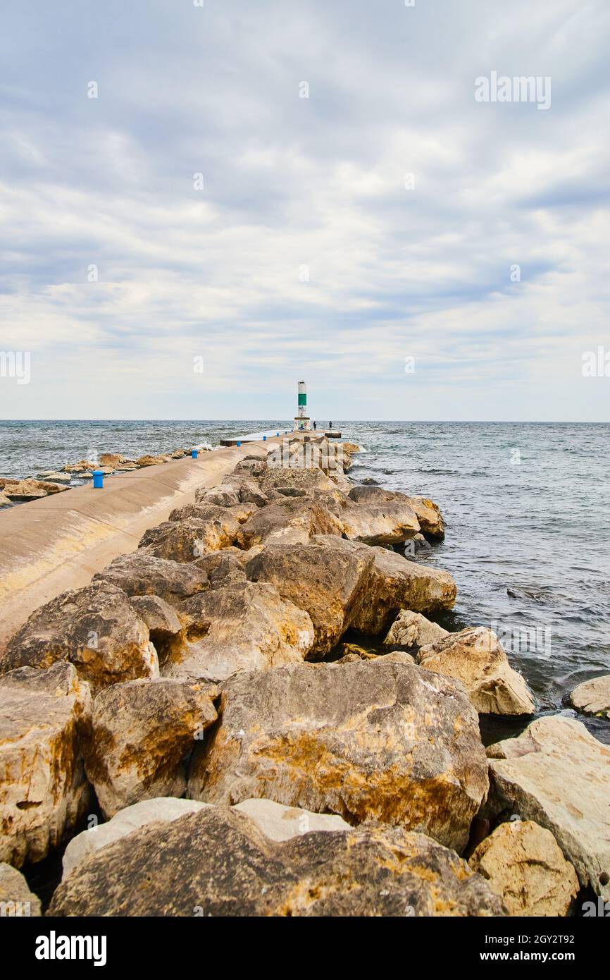 Massi vicino al molo di cemento vicino al lago Foto Stock