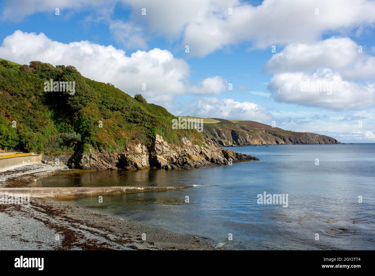 La vista a nord dalla baia di Port Soderick nell'isola di Man mostra il promontorio verso Douglas e parte della spiaggia di pietra Foto Stock