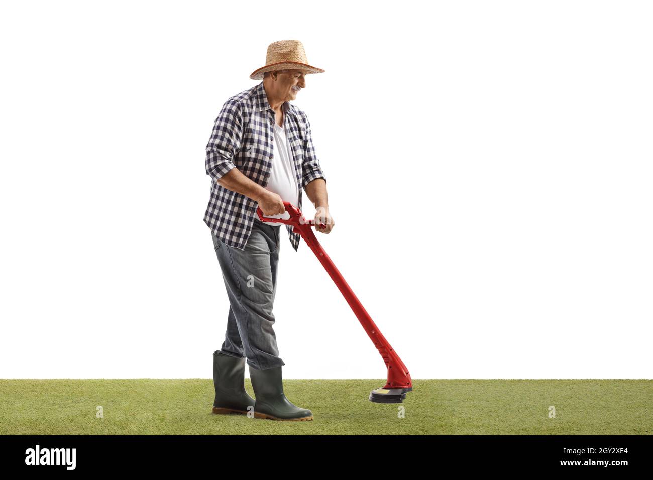 Scatto completo di un uomo maturo che taglia l'erba con un tagliabasette isolato su sfondo bianco Foto Stock