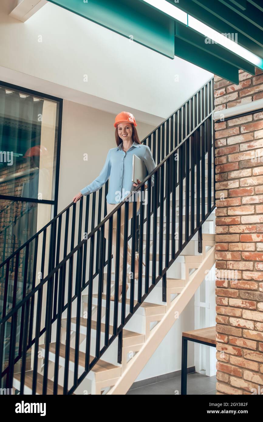 Felice giovane donna su passi in nuovo edificio Foto Stock