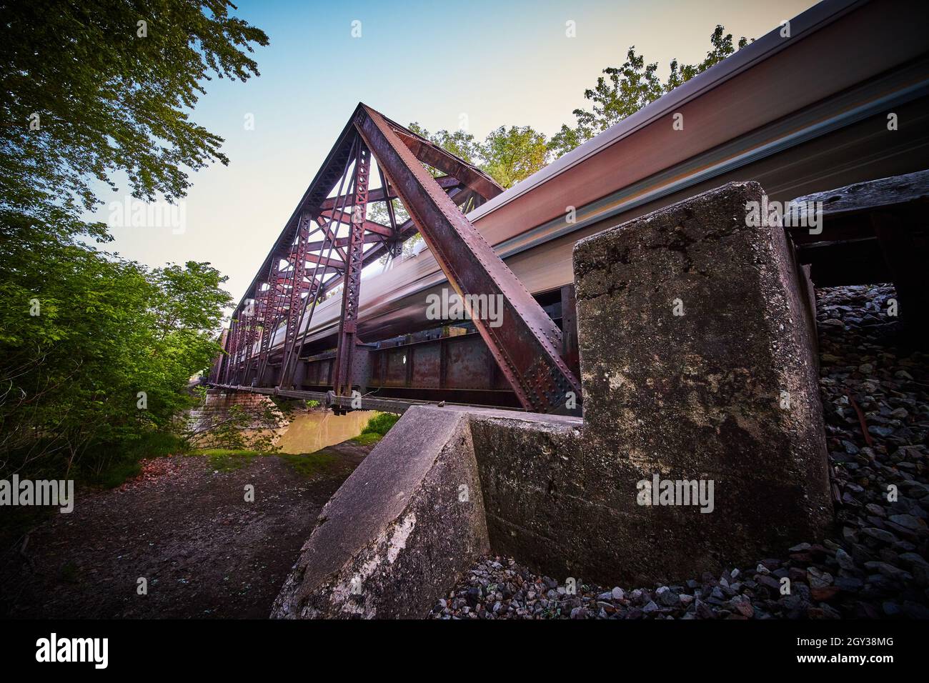Fine del ponte di metallo per il treno con sfocatura di passaggio del treno Foto Stock