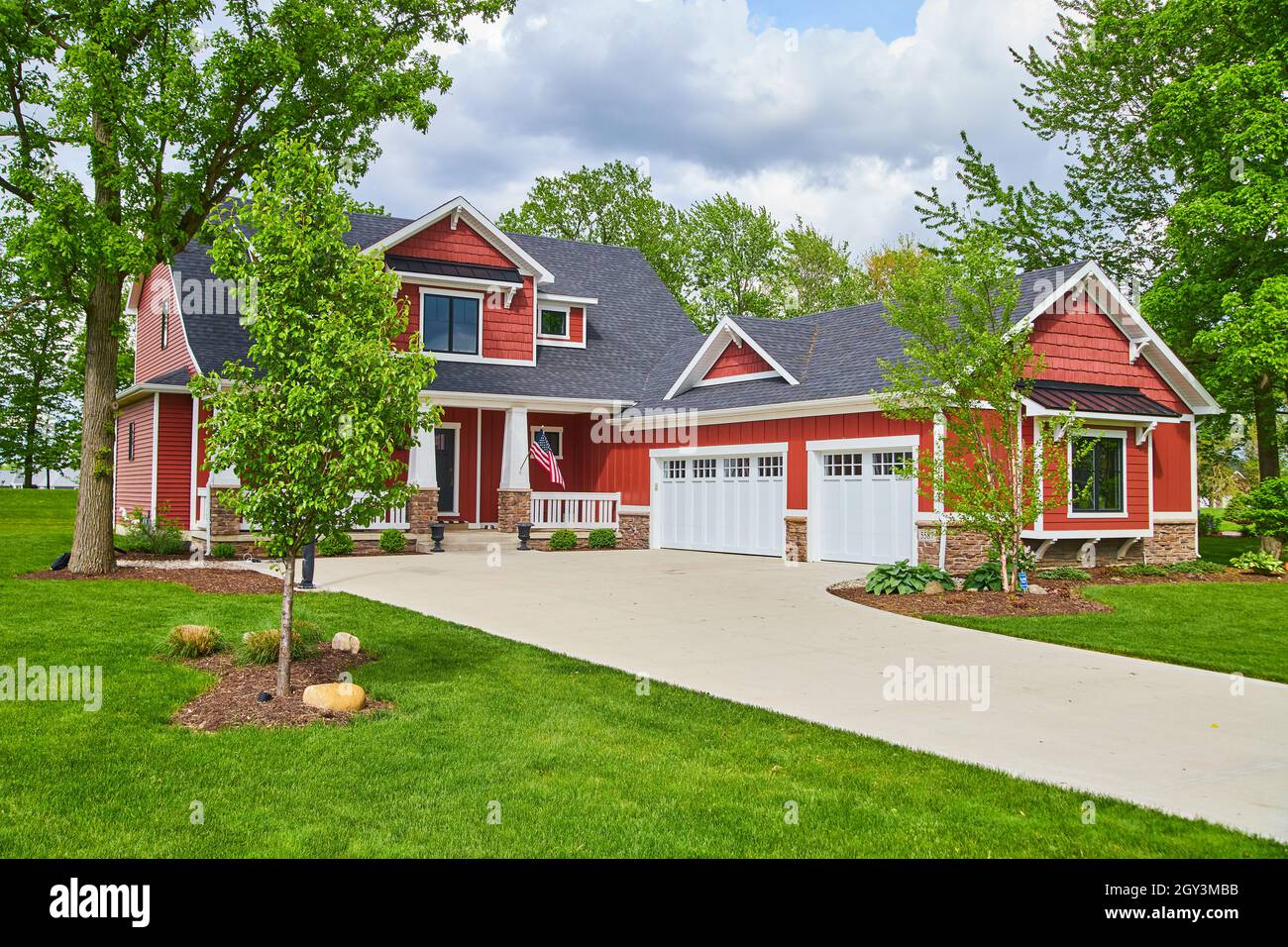 American Northeast casa a 2 piani in estate con rosso siding e bella erba verde Foto Stock