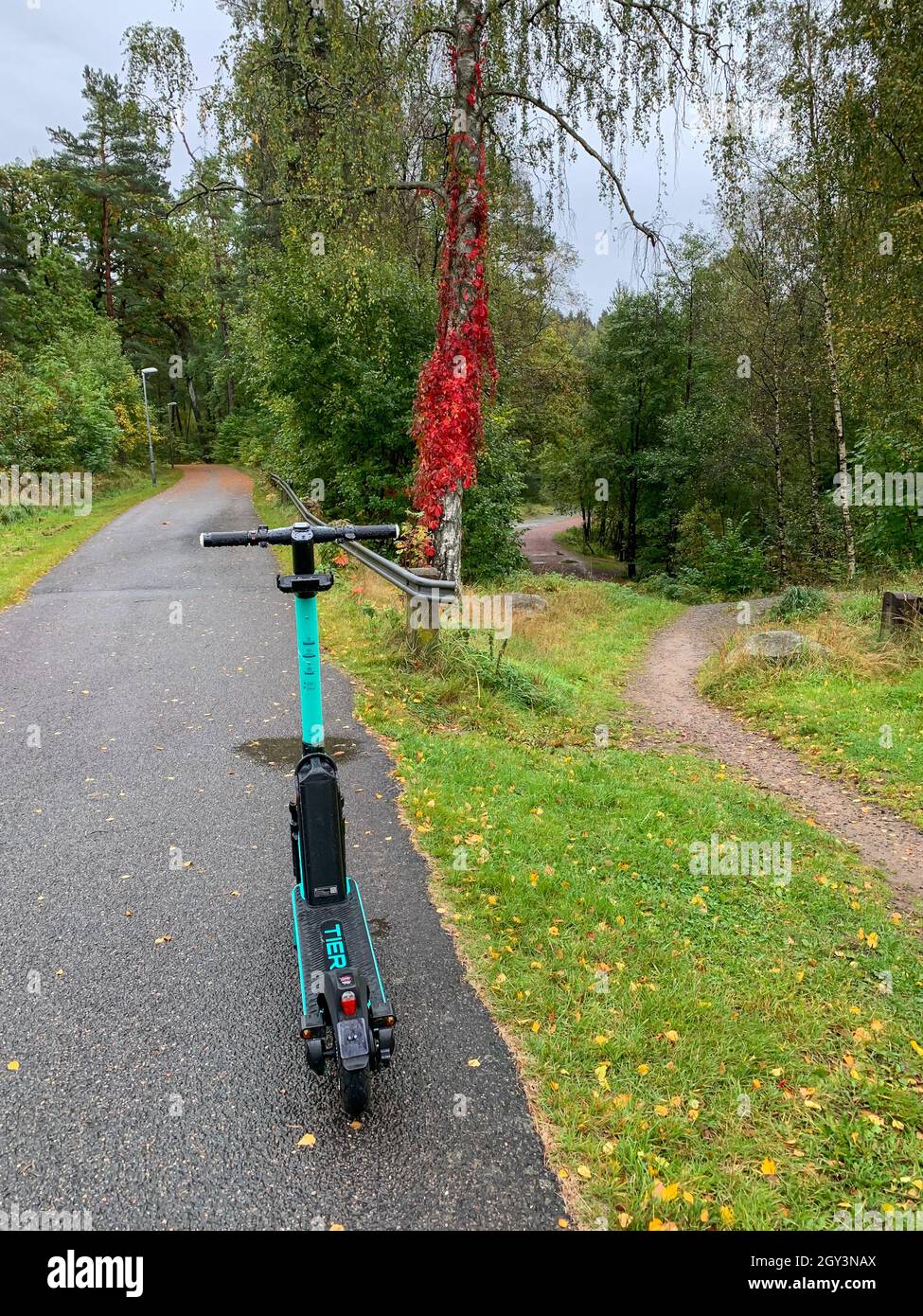 PARTILLE, SVEZIA - 28 settembre 2021: Partille, Svezia, 28 settembre 2021. Scooter elettrico abbandonato nel mezzo di un passaggio pedonale, pista ciclabile. Foto Stock