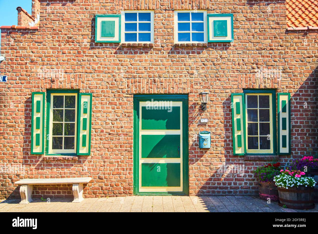 Architettura olandese con porte verdi e gialle e persiane in mattoni rossi Foto Stock