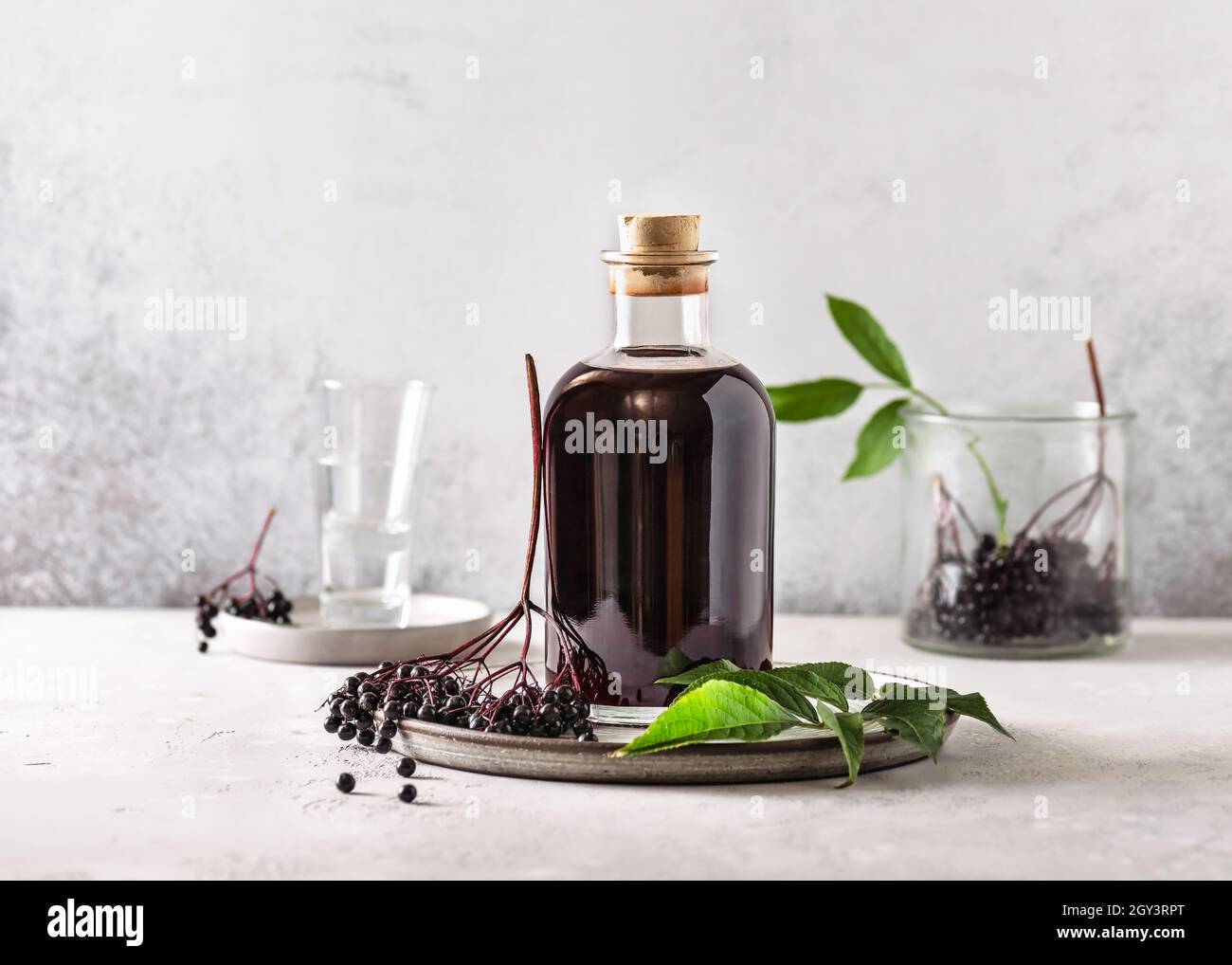 Delizioso liquore di sambuco nero in bottiglia di vetro. Concetto di cibo fatto in casa. Spazio di copia. Foto Stock