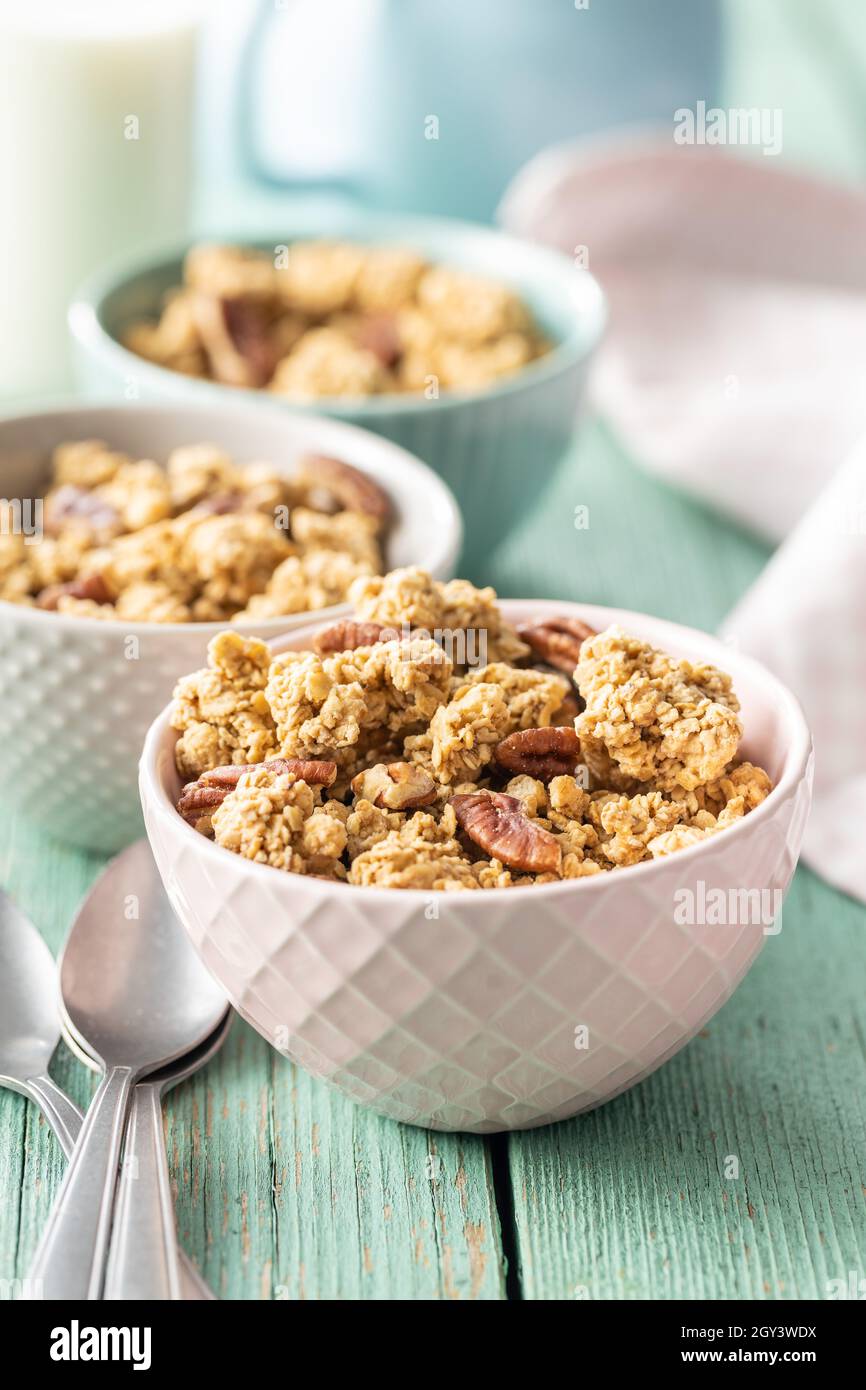 Cereali dolci alla granola in ciotola su tavola di legno verde. Foto Stock