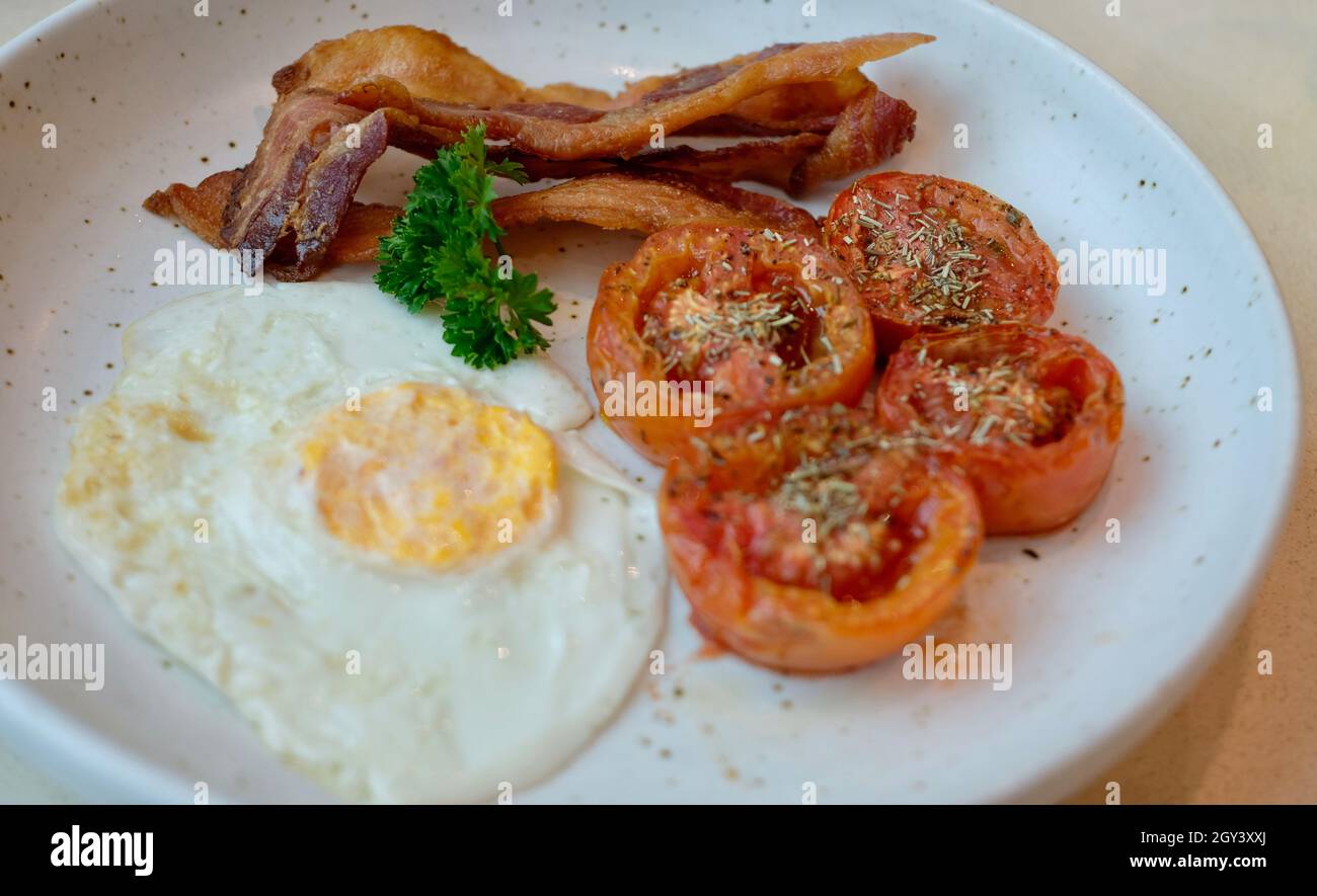 Pancetta di prezzemolo e uova e pomodori rosmarino su un piatto colazione pasto mattina Foto Stock
