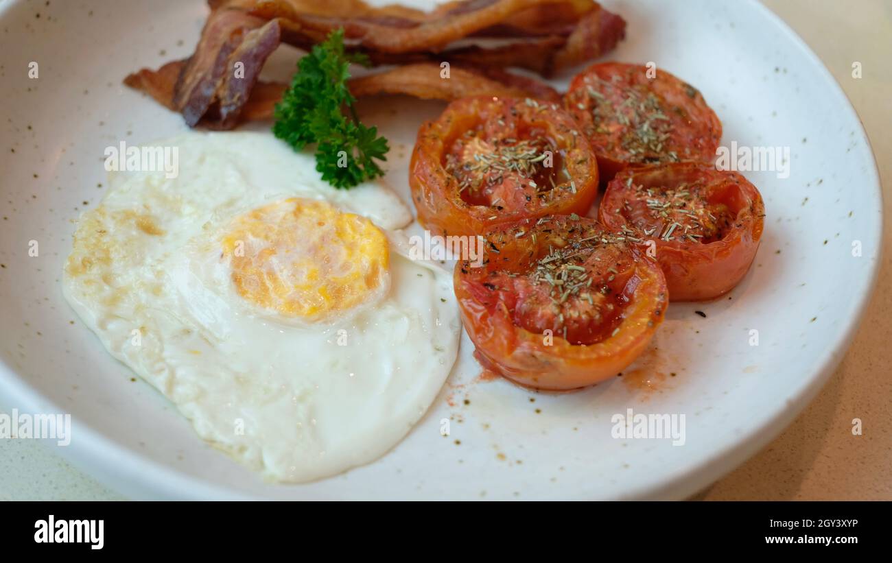 Pancetta di prezzemolo e uova e pomodori rosmarino su un piatto colazione pasto mattina Foto Stock