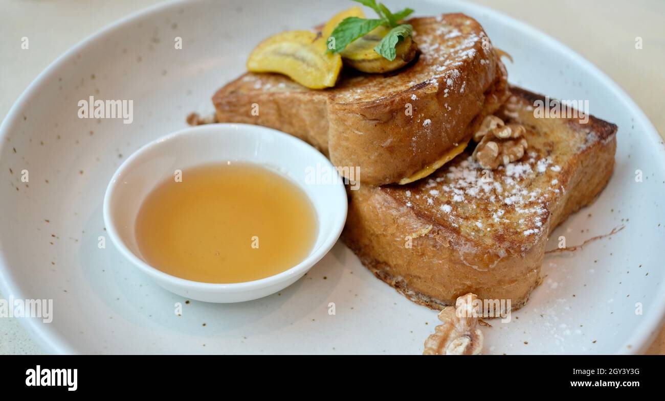 Menta lasciare su pane Banana toast alla francese con noci Banana e miele Foto Stock