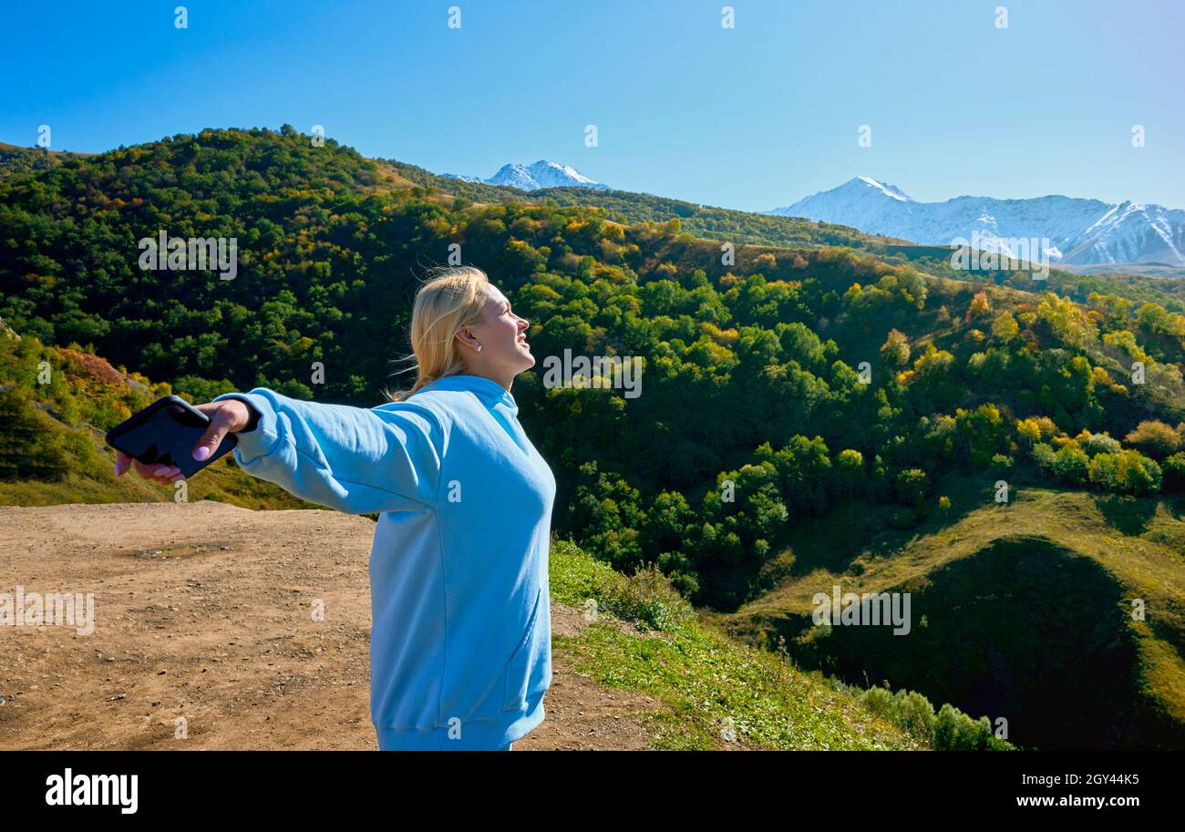 donna che cammina in erba e tiene in mano i fiori selvatici delle erbe in montagna estate, concetto di viaggio, momento di relax pacifico. giornata di terra felice Foto Stock