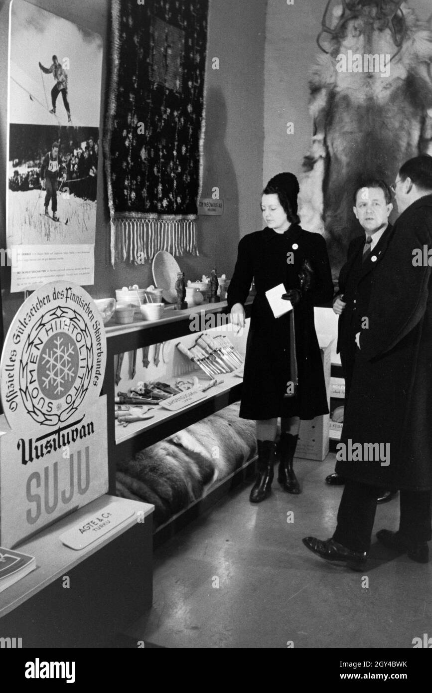 Besucher der Leipziger Frühjahrsmesse im Gespräch mit einem Verkäufer, Deutschland 1941. I visitatori della Leipziger Frühjahrsmesse sotto la discussione con un assistente vendite, Germania 1941. Foto Stock