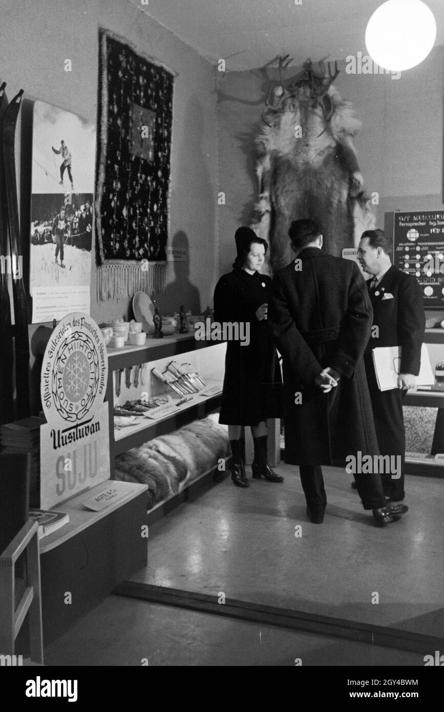 Besucher der Leipziger Frühjahrsmesse im Gespräch mit einem Verkäufer, Deutschland 1941. I visitatori della Leipziger Frühjahrsmesse sotto la discussione con un assistente vendite, Germania 1941. Foto Stock