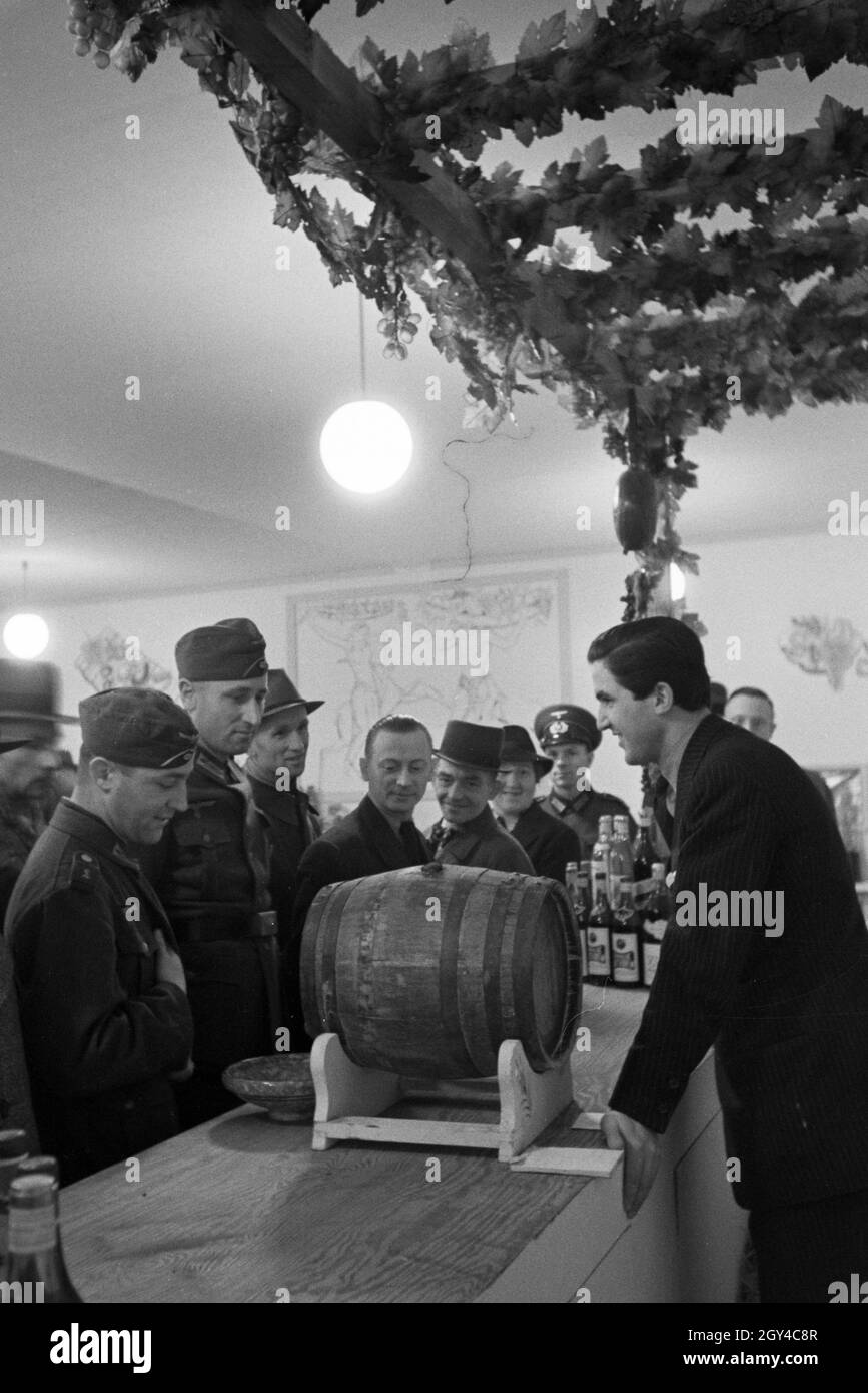 Besucher der Leipziger Frühjahrsmesse vor einem Schanktisch mit landestypischen Getränken; Deutschland 1941. I visitatori del Leipziger Frühjahrsmesse di fronte a un bar con bevande tradizionali; Germania 1941. Foto Stock