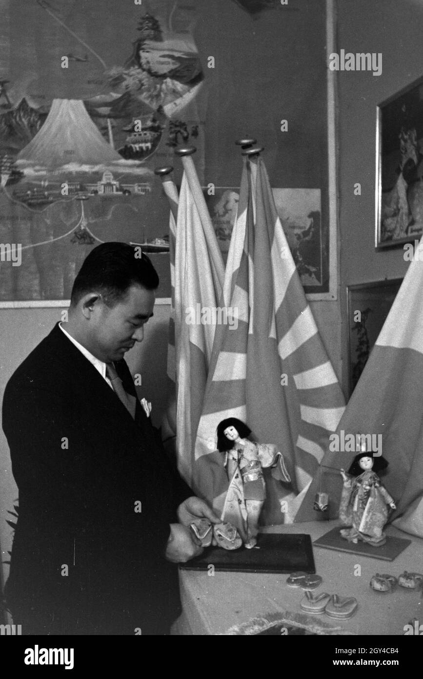 Angestellter der Leipziger Frühjahrsmesse an einem japanischen Messestand; Deutschland 1941. Dipendente del Leipziger Frühjahrsmesse di fronte ad uno stand giapponese; Germania 1941. Foto Stock