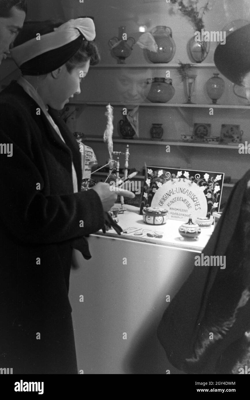 Besucher der Wiener Modewoche, im Haus der Mode 'Palais Lobkowitz', vor einem Schaukasten mit ungarischem Kunsthandwerk; Deutschland 1940er Jahre. I visitatori della settimana della moda di Vienna, nella casa della moda 'Palais Lobkowitz', di fronte a una vetrina con arte e artigianato ungherese; Germania 1940. Foto Stock