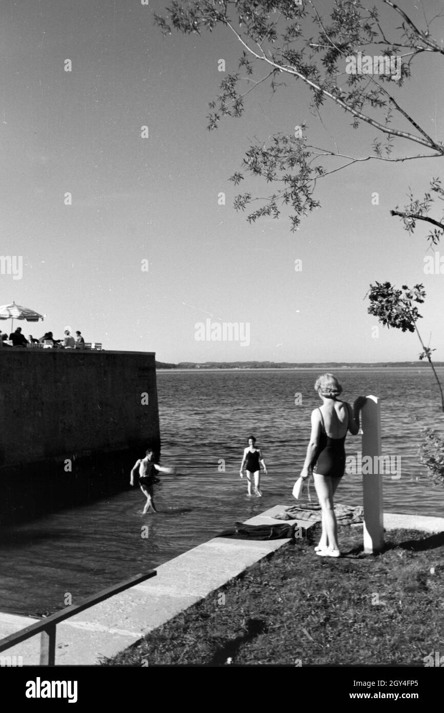 Zwei Junge Frauen und ein junger Mann beim Sonnenbaden und schwimmen im Chiemsee, Deutschland 1930er Jahre. Due giovani donne e un giovane uomo che si prende il sole e nuota nel Chiemsee, Dermany anni trenta. Foto Stock