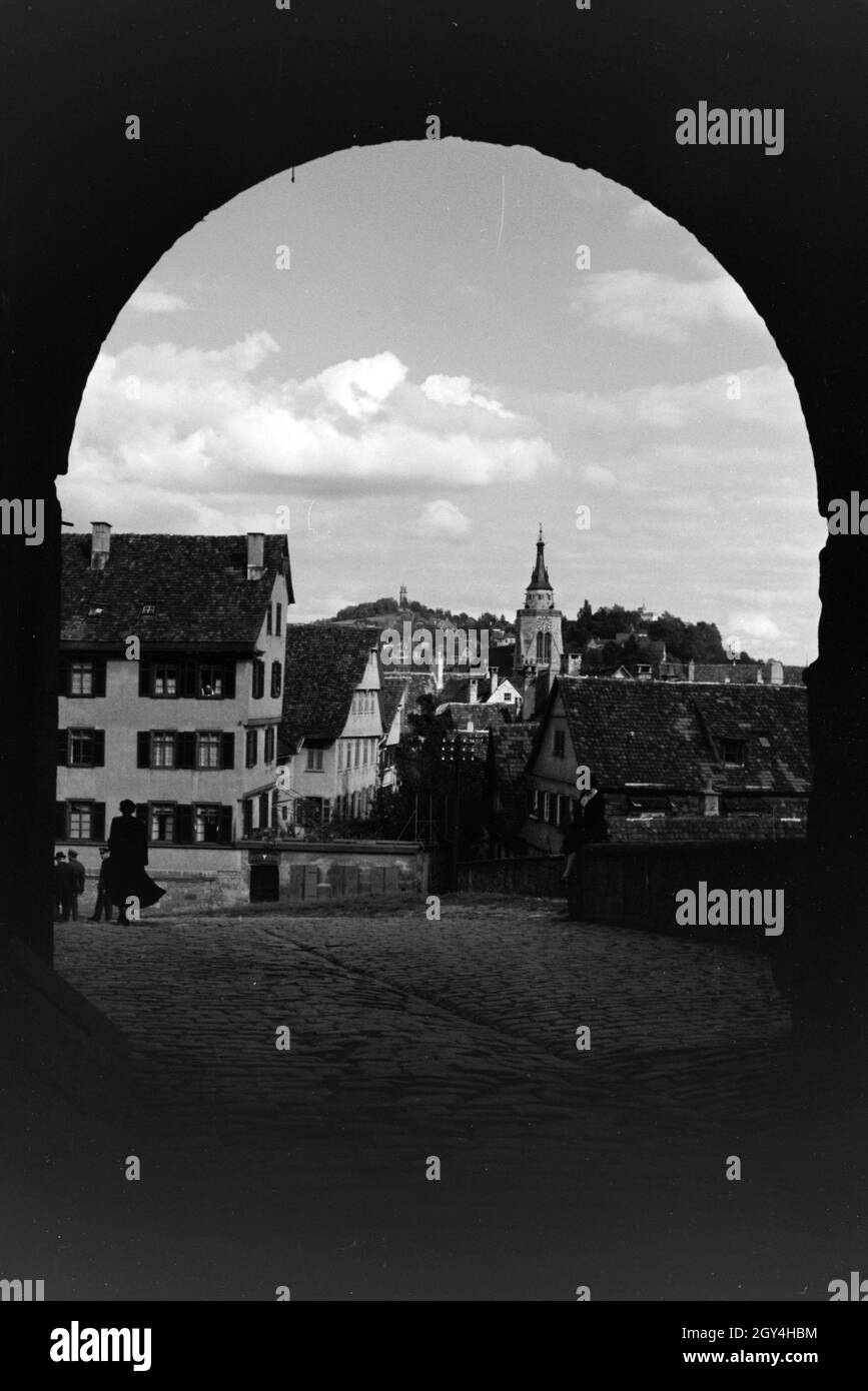 Der Blick auf die Altstadt Tübingens durch das Untere Schlosstor des Schlosses Hohentübinger, Tübingen, Deutschland 1930er Jahre. La vista del quartiere storico di Tübingen attraverso il castello inferiore cancello del castello Hohentübinger, Tubinga, Germania 1930s. Foto Stock