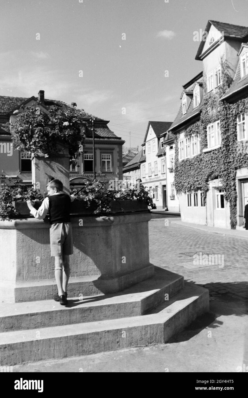 Ein Junge steht am Springbrunnen auf dem Marktlatz von Bad Blankenburg, Deutschland 1930er Jahre. Un ragazzo in piedi accanto alla fontana sulla piazza del mercato di Bad Blankenburg, Germania 1930s. Foto Stock