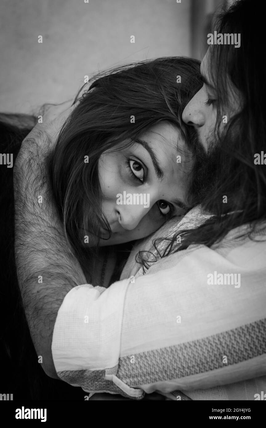 Ritratto in bianco e nero di una giovane coppia abbracciante tenendola tenera tenendola stretta in un momento di tenerezza Foto Stock