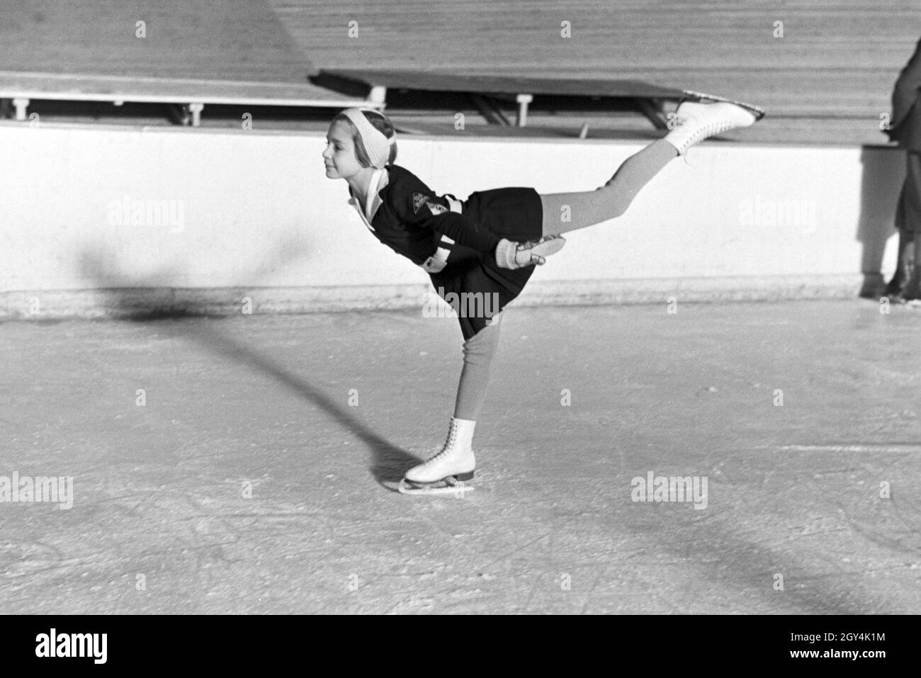 Eine BDM Kindereisläuferin mit den Hitlerjugend Aufnähern und Hakenkreuzemblem dem auf der Kleidung während eines corsi mit dem österreichischen Eiskunstläufer und Olympiasieger Karl Schäfer, Deutschland 1930er Jahre. Un BDM bambini figureskaters con la Gioventù Hitleriana patch e la svastica simbolo sul suo abbigliamento durante un allenamento con il figureskater austriaco e alle Olimpiadi champion Karl Schäfer, Germania 1930s. Foto Stock