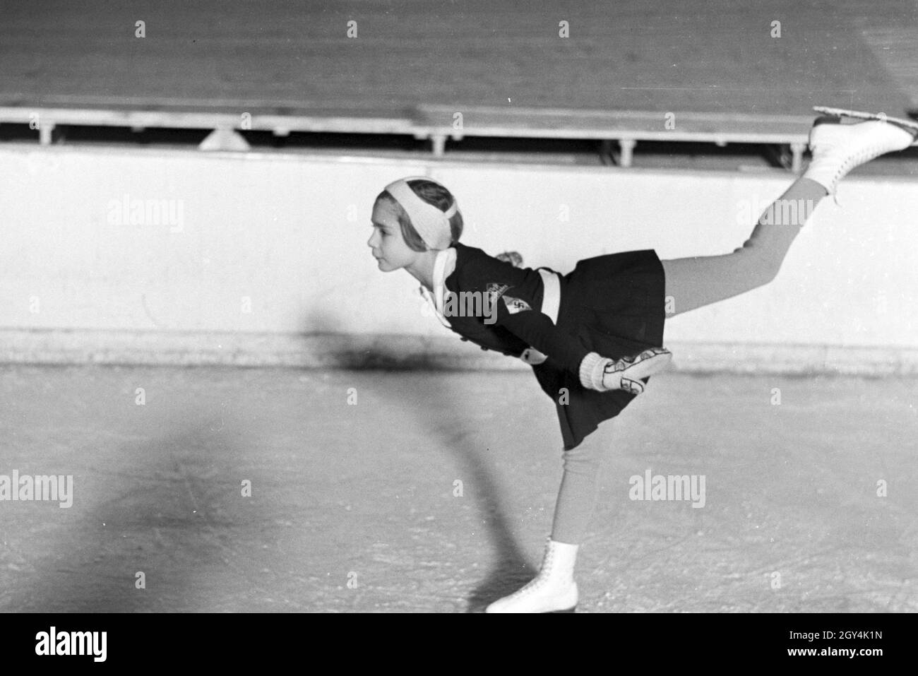 Eine BDM Kindereisläuferin mit den Hitlerjugend Aufnähern und Hakenkreuzemblem dem auf der Kleidung während eines corsi mit dem österreichischen Eiskunstläufer und Olympiasieger Karl Schäfer, Deutschland 1930er Jahre. Un BDM bambini figureskaters con la Gioventù Hitleriana patch e la svastica simbolo sul suo abbigliamento durante un allenamento con il figureskater austriaco e alle Olimpiadi champion Karl Schäfer, Germania 1930s. Foto Stock