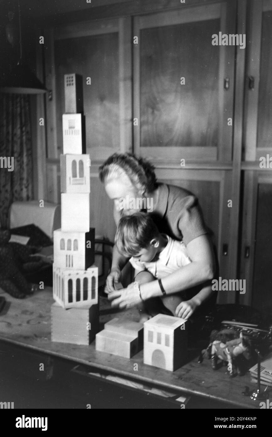 Eine Kunsthandwerkerin zeigt einem Jungen neue Spielsachen, Deutsches Reich 1930er Jahre. Un artigiano che mostra i nuovi giocattoli di un ragazzo, Germania 1930s. Foto Stock