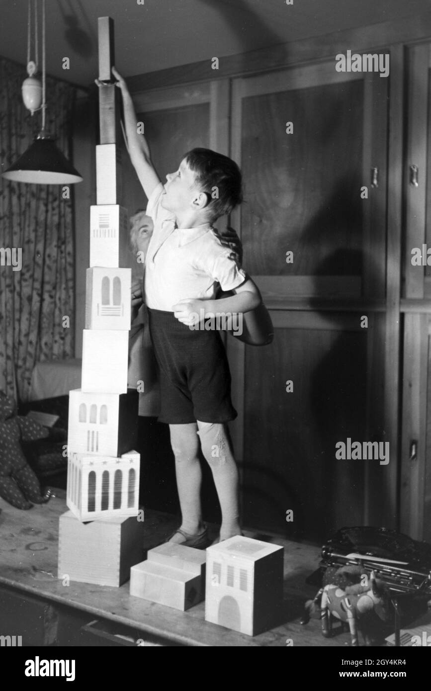 Eine Kunsthandwerkerin zeigt einem Jungen neue Spielsachen, Deutsches Reich 1930er Jahre. Un artigiano che mostra i nuovi giocattoli, Germania 1930s. Foto Stock